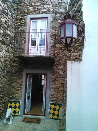 a cat sitting in front of a building with a window at Casa Rural Santa Teresinha in Campo de Víboras