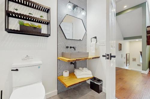 a bathroom with a toilet and a sink and a mirror at Serenity Woods Family Retreat in Glen Lord