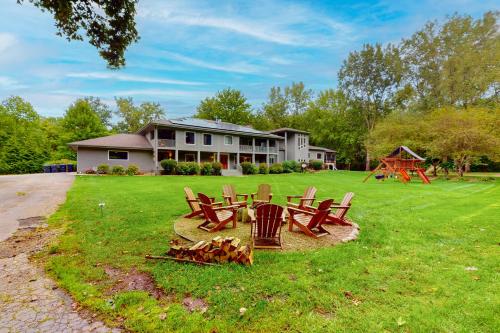 a yard with chairs and a fire pit in front of a house at Serenity Woods Family Retreat in Glen Lord