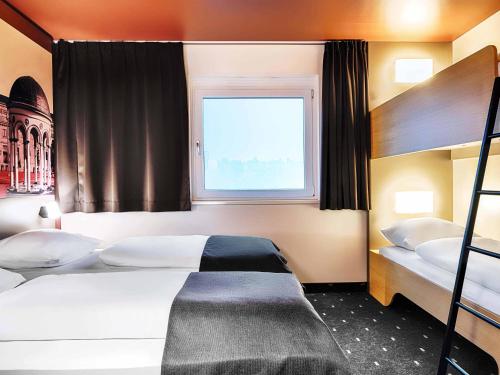 a bedroom with two bunk beds and a window at B&B HOTEL Wiesbaden-Hbf in Wiesbaden