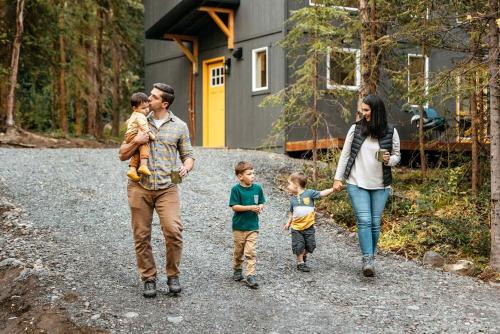 a family walking in front of a house at Gorgeous Cabin Settled in the Middle of the Mountain in Anchorage, Alaska in Chugiak