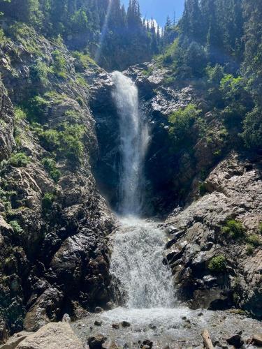 a waterfall on the side of a mountain at Guest house and yurt camp Svetlana in Bokonbayevo