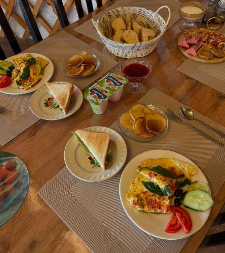 a wooden table with plates of food on it at Guest house and yurt camp Svetlana in Bokonbayevo