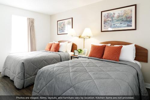 two beds in a hotel room next to a window at InTown Suites Extended Stay Mobile AL - Tillmans Corner in Mobile