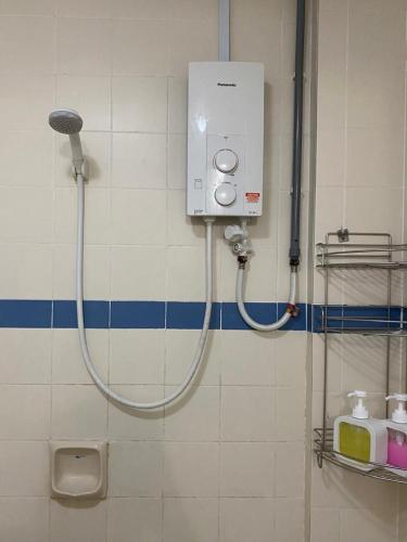 a shower in a bathroom with a hose on a wall at BAYU BEACH APARTMENT By FIONAMALIK GUESTHOUSES in Port Dickson