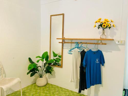 a dressing room with a mirror and a blue shirt at Lungkluay homestay in Ko Kood