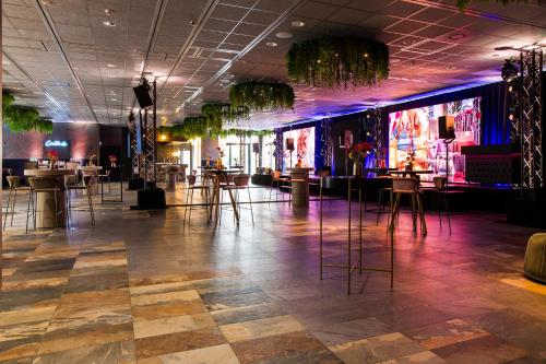 a lobby with tables and chairs and a dance floor at Haven Hotel Rotterdam, Curio Collection by Hilton in Rotterdam
