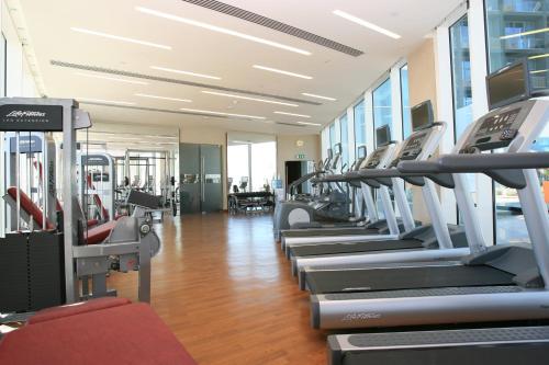 a gym with a row of treadmills and machines at Yas Plaza Marina by IHG in Abu Dhabi