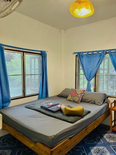 a bedroom with a bed with blue drapes at Lungkluay homestay in Ko Kood