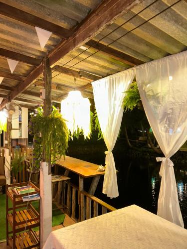 a patio with a table with plants and a ceiling at Lungkluay homestay in Ko Kood
