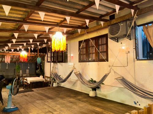 two hammocks in a room with a table and a couch at Lungkluay homestay in Ko Kood