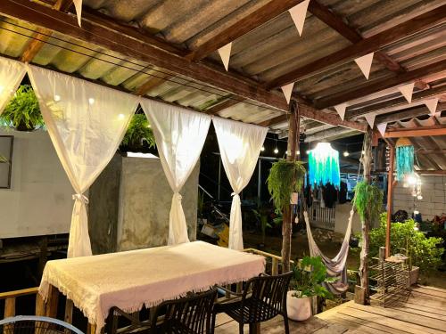 a table and chairs on a patio with curtains at Lungkluay homestay in Ko Kood