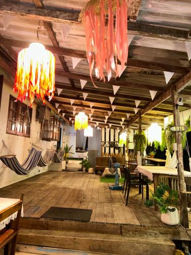 a large living room with wooden floors and chandeliers at Lungkluay homestay in Ko Kood