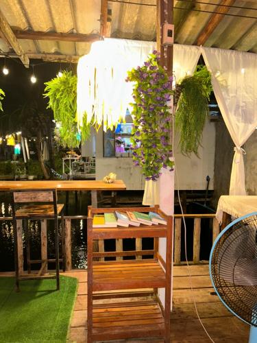 a bar with a table and a bench with flowers at Lungkluay homestay in Ko Kood