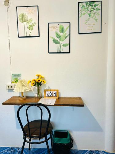 a desk with a chair and some pictures on the wall at Lungkluay homestay in Ko Kood