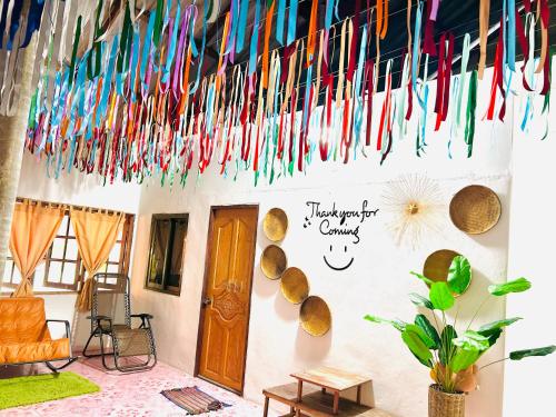 a room with colorful streamers hanging from a wall at Lungkluay homestay in Ko Kood