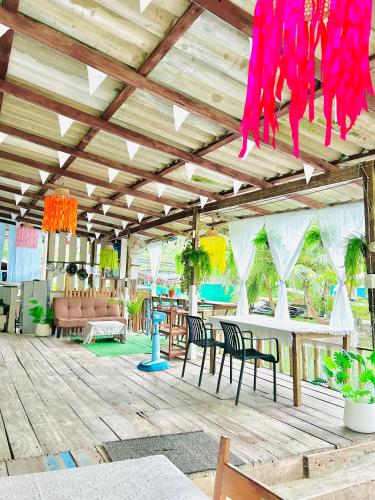 a patio with a table and chairs and pink strings at Lungkluay homestay in Ko Kood