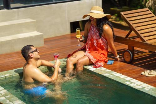 a man and a woman sitting in a swimming pool at Makini Bush Camp, Yala in Yala