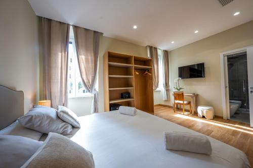 a bedroom with a large white bed and a desk at MAMA Luxury in Rome