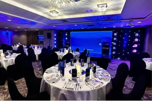 a banquet room with tables and chairs and a projection screen at Holiday Inn Newcastle South by IHG in Boldon