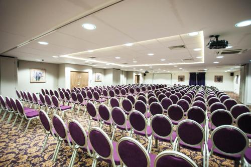 an empty room with purple chairs in a building at Holiday Inn Newcastle South by IHG in Boldon