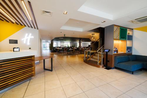 a lobby with a blue couch and a table at Holiday Inn Newcastle South by IHG in Boldon