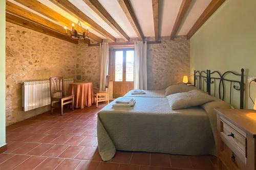 Un dormitorio con una cama y una mesa en una habitación. en La Marcela, en Aldea de San Esteban