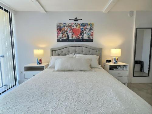 a bedroom with a large white bed with two lamps at Sandy Cove - Unit 401 in Bailey Hall