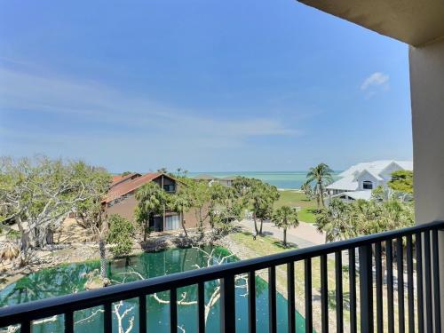 a balcony with a view of a house and the ocean at Sandy Cove - Unit 401 in Bailey Hall