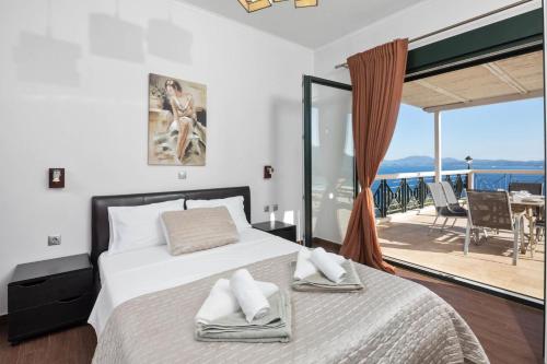 a bedroom with a bed and a view of the ocean at Anna Nissaki in Corfu