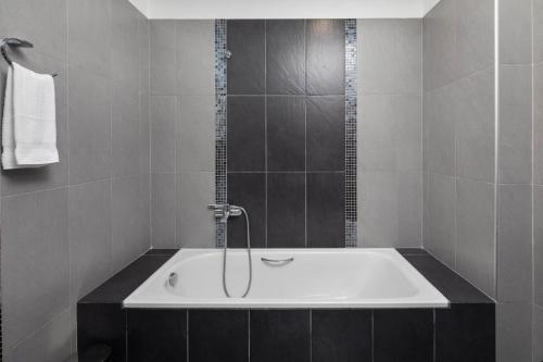 a bathroom with a bath tub with a shower at Anna Nissaki in Corfu