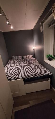 a bed in a small room with a wall at Mountainview apartment in Storsteinnes