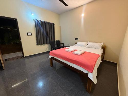 a bedroom with a bed with a red blanket at Omisha Beach Stay Gokarna in Gokarna