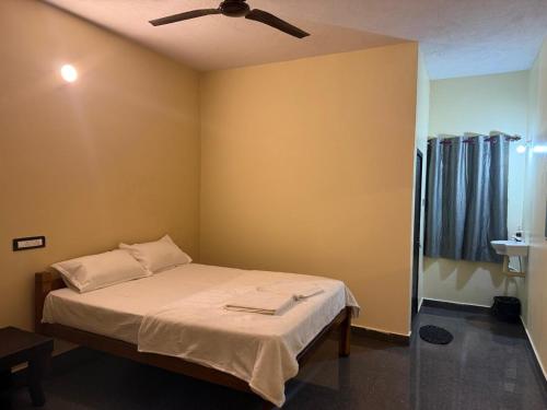 ゴカルナにあるOmisha Beach Stay - Just a 2 minute walk to the beachのベッドルーム1室(ベッド1台、シーリングファン付)