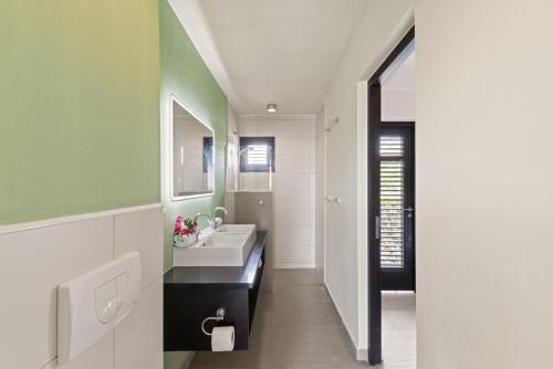 a bathroom with a sink and a mirror at New bungalow 466 Blue Bay in Blue Bay