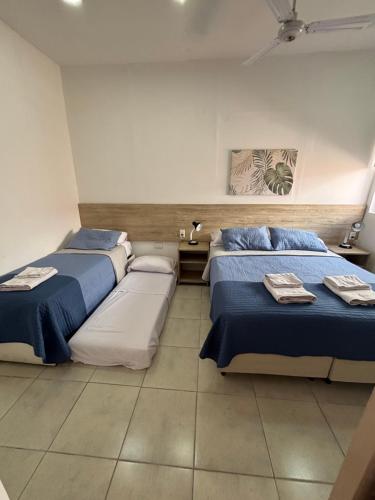 two beds in a room with blue and white at Multiespacio Center in San Fernando del Valle de Catamarca