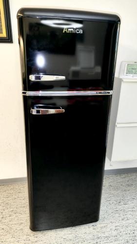 a black refrigerator freezer sitting on top of a counter at Künstlerhaus Arthotel in Geislingen