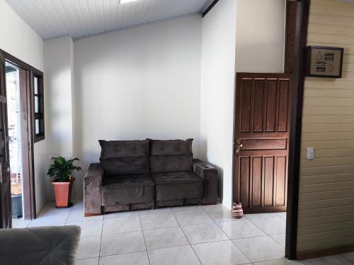 a brown couch sitting in a living room next to a door at La Casa de Gramado in Gramado