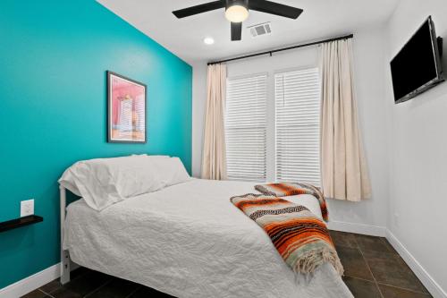 a bedroom with a bed with a blue wall at New Luxury Pearl Townhome-Casa A in San Antonio