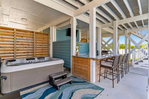 a porch with a tub and a table and chairs at Sunny Second Row Beach and BIG views in Varnamtown
