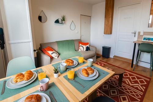 Una sala de estar con una mesa con platos de croissants. en Le Green, en Boulogne-sur-Mer