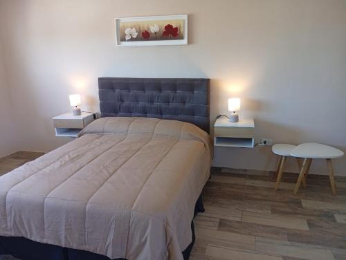 a bedroom with a large bed and two lamps at departamento la punta in La Punta