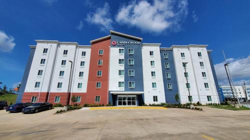 a large building with a parking lot in front of it at Candlewood Suites - Lake Charles South by IHG in Lake Charles