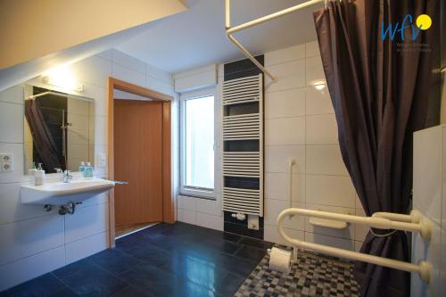 a bathroom with a sink and a window at Haus Gartenstraße Ferienwohnung Nemo in Borkum