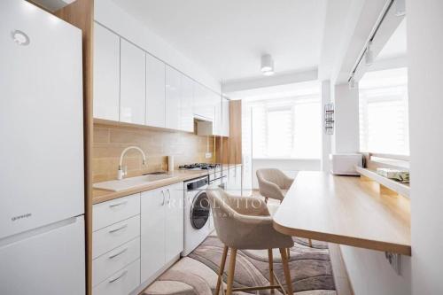 a kitchen with white cabinets and a table and chairs at Fine RelaxStudio in Chişinău