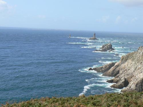 a view of the ocean with a lighthouse in the distance at Appt 300m de la plage vue sur mer in Audierne