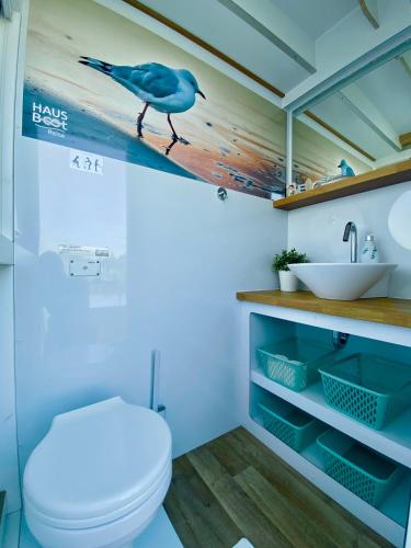 a bathroom with a toilet and a bird on the wall at HAUSBOOT - Schwimmende feststehende Ferienwohnung direkt auf der Havel mit Weitblick aufs Wasser in Ketzin