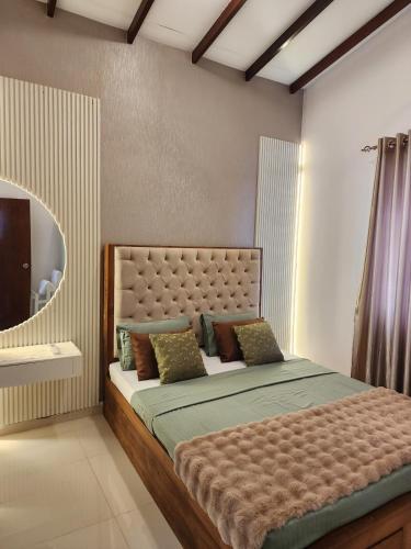 a bedroom with a large bed and a mirror at The Ultimate Escape in Negombo