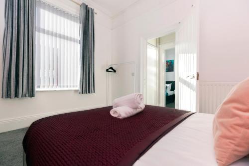 a bedroom with a bed with a pink towel on it at Newly Renovated 3br House Near Hospital & Uni in Sunderland