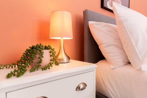 a lamp on a night stand next to a bed at Newly Renovated 3br House Near Hospital & Uni in Sunderland